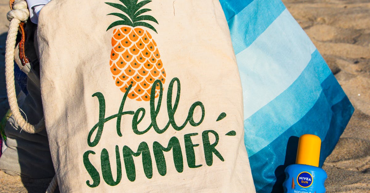 Colorful beach bag and sunscreen evoke a vibrant summer vibe on the sandy beach.