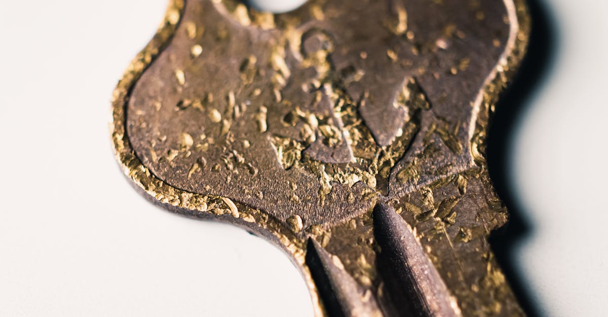 Detailed macro shot of a vintage brass key with textured patina, lying on a light background.
