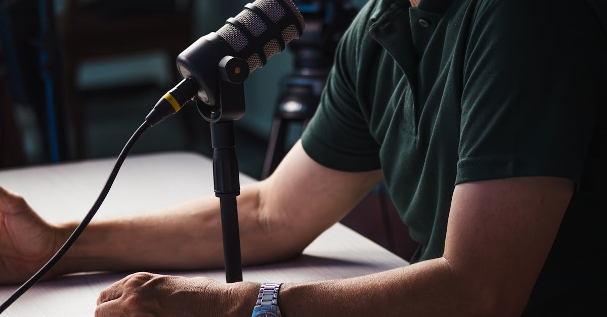 Close-up of a person recording a podcast in a studio, featuring a microphone and professional audio equipment.