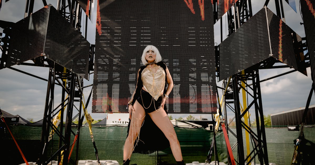 A stylish female performer in bold attire striking a pose on an outdoor stage.