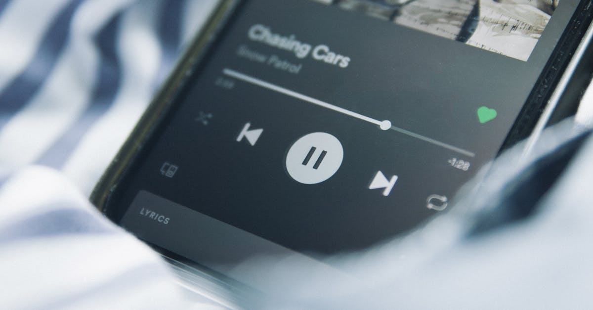 Close-up of a smartphone streaming music on a striped fabric background.